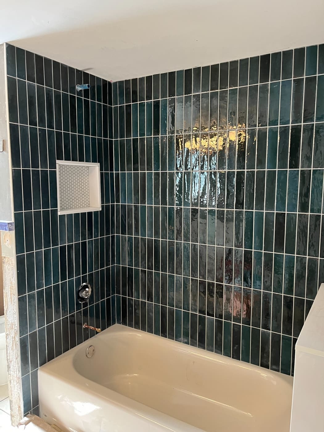 Remodeled tub and shower with deep green vertical stacked tile